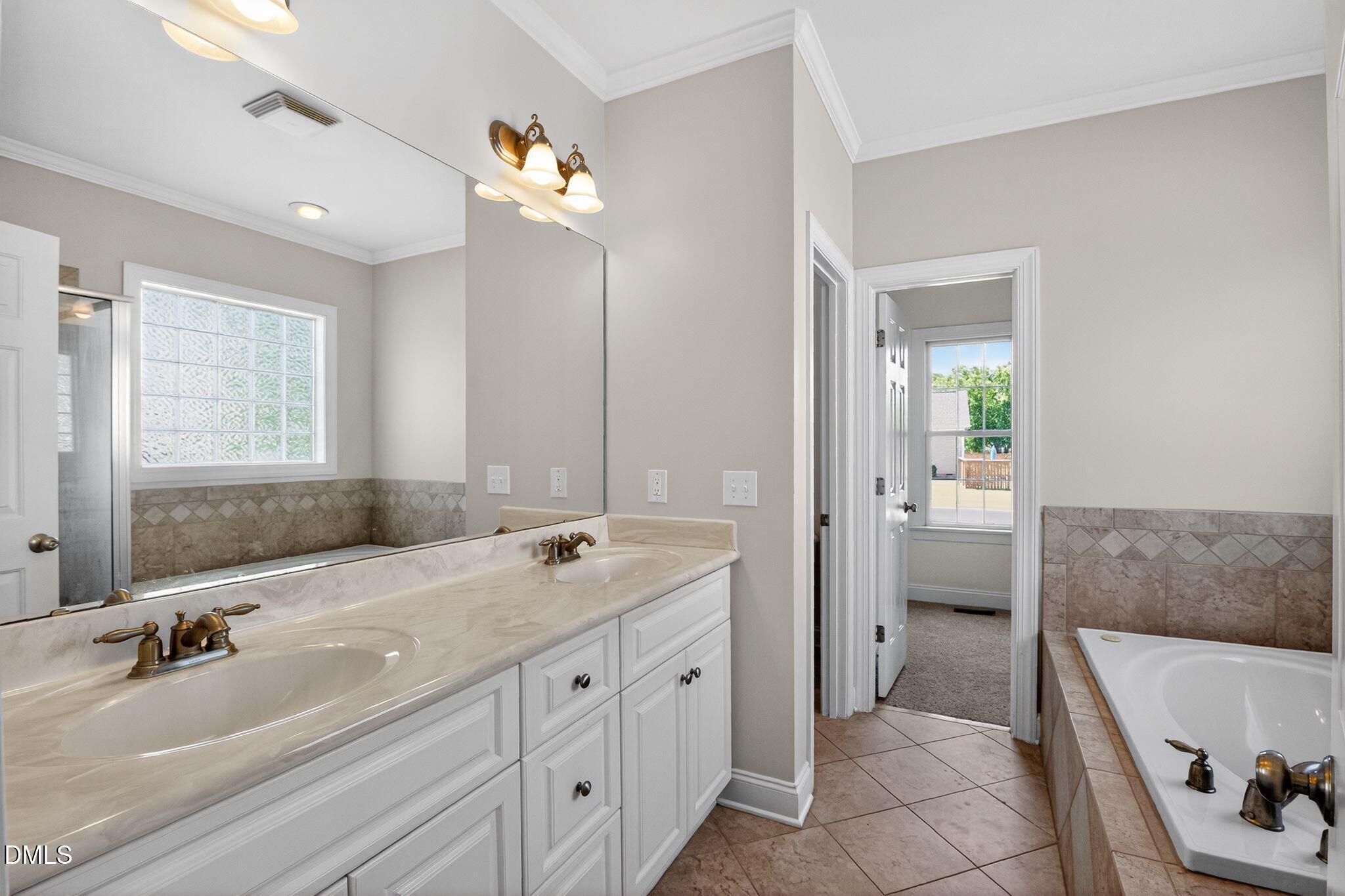 8725 Oregon Inlet Court Raleigh, NC 27603 - Photo 17 of 31 a spacious bathroom with a tub sink and mirror