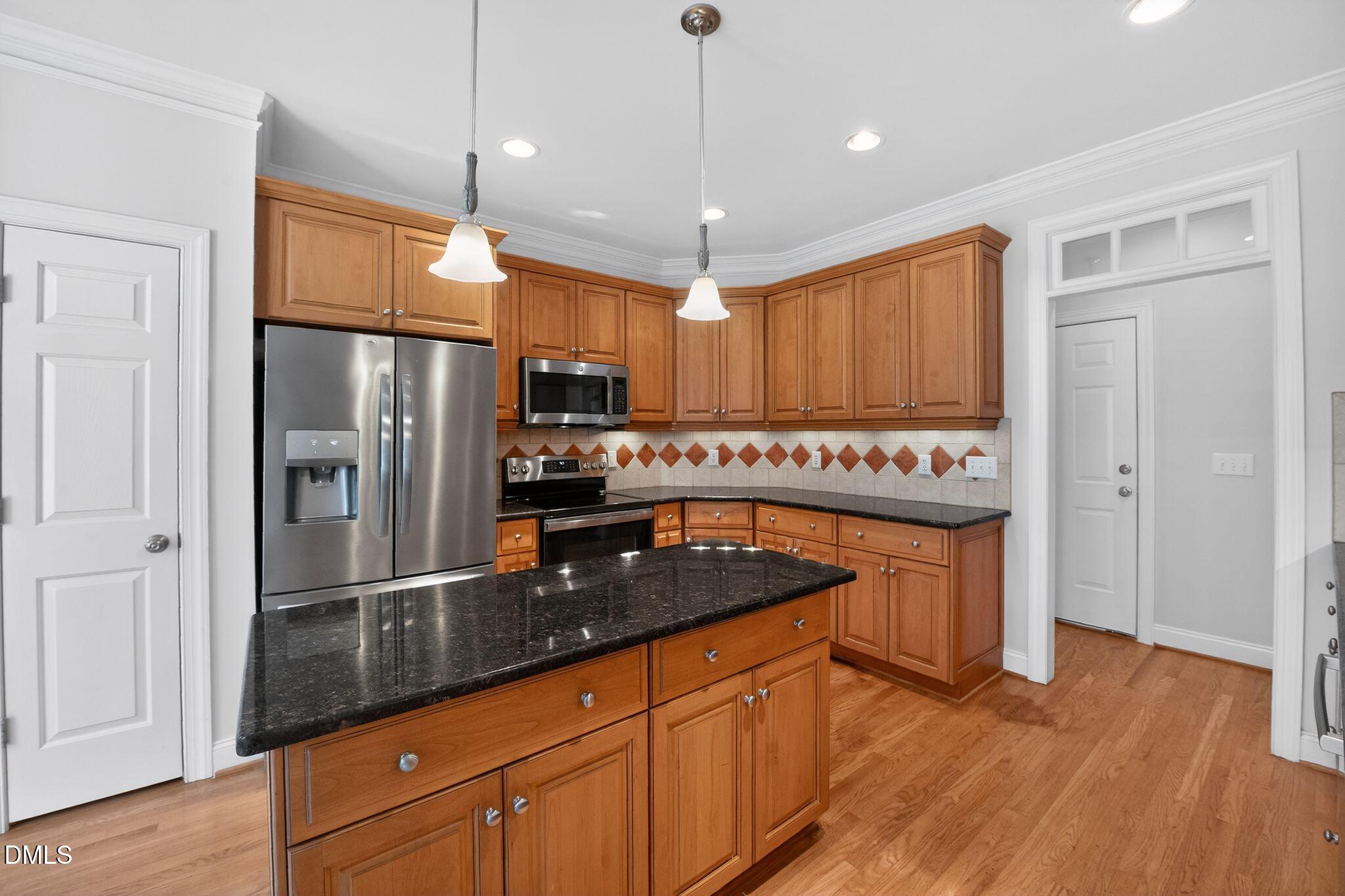 8725 Oregon Inlet Court Raleigh, NC 27603 - Photo 8 of 31 a kitchen with stainless steel appliances granite countertop a refrigerator a sink and a stove