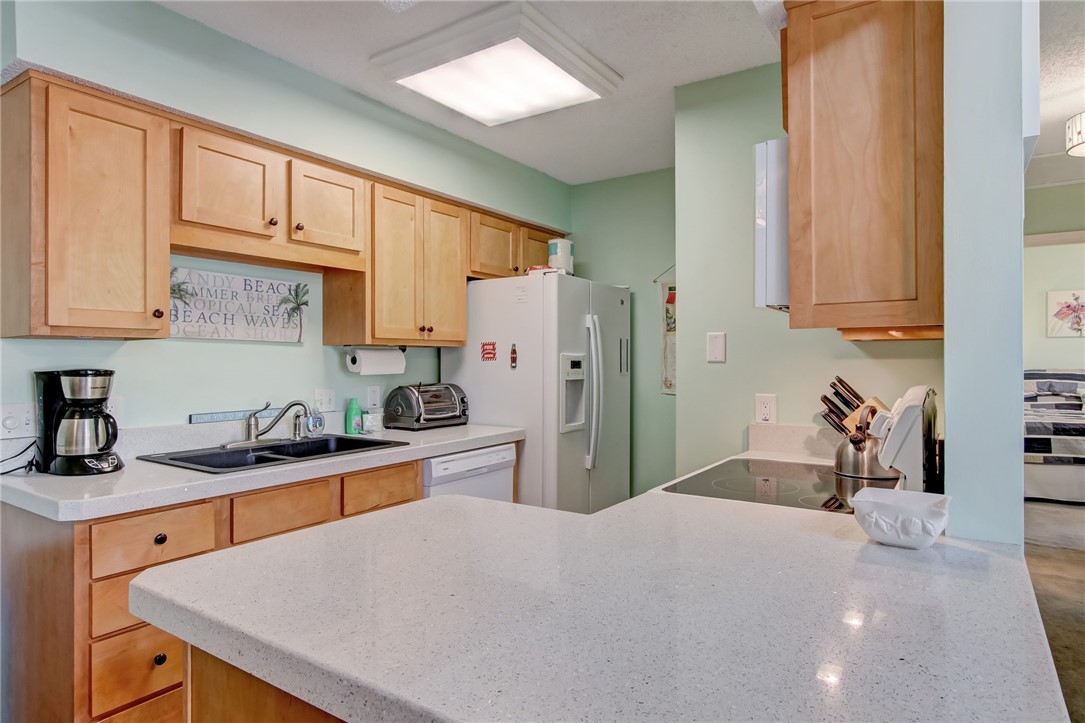 2745 Forest Ridge Drive, Unit I5 Fernandina Beach, FL 32034 - Photo 9 of 32 a kitchen with stainless steel appliances granite countertop a sink refrigerator and cabinets
