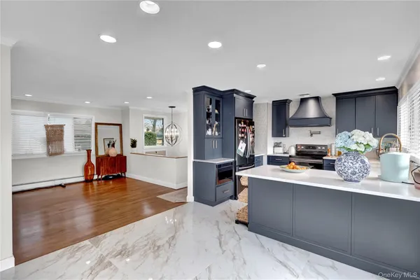a kitchen view of a kitchen center island stainless steel appliances cabinets and living room view