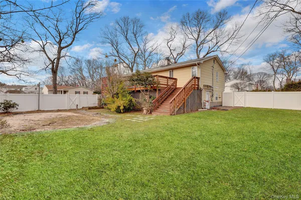 a view of backyard with a huge green area and wooden fence