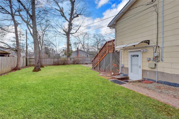 a view of a house with backyard and a tree