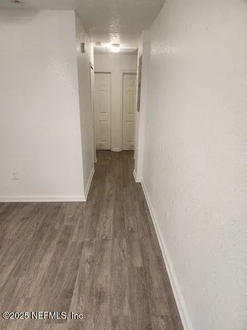 a view of a hallway with wooden floor