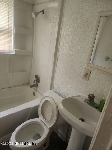 a bathroom with a sink a toilet and bathtub