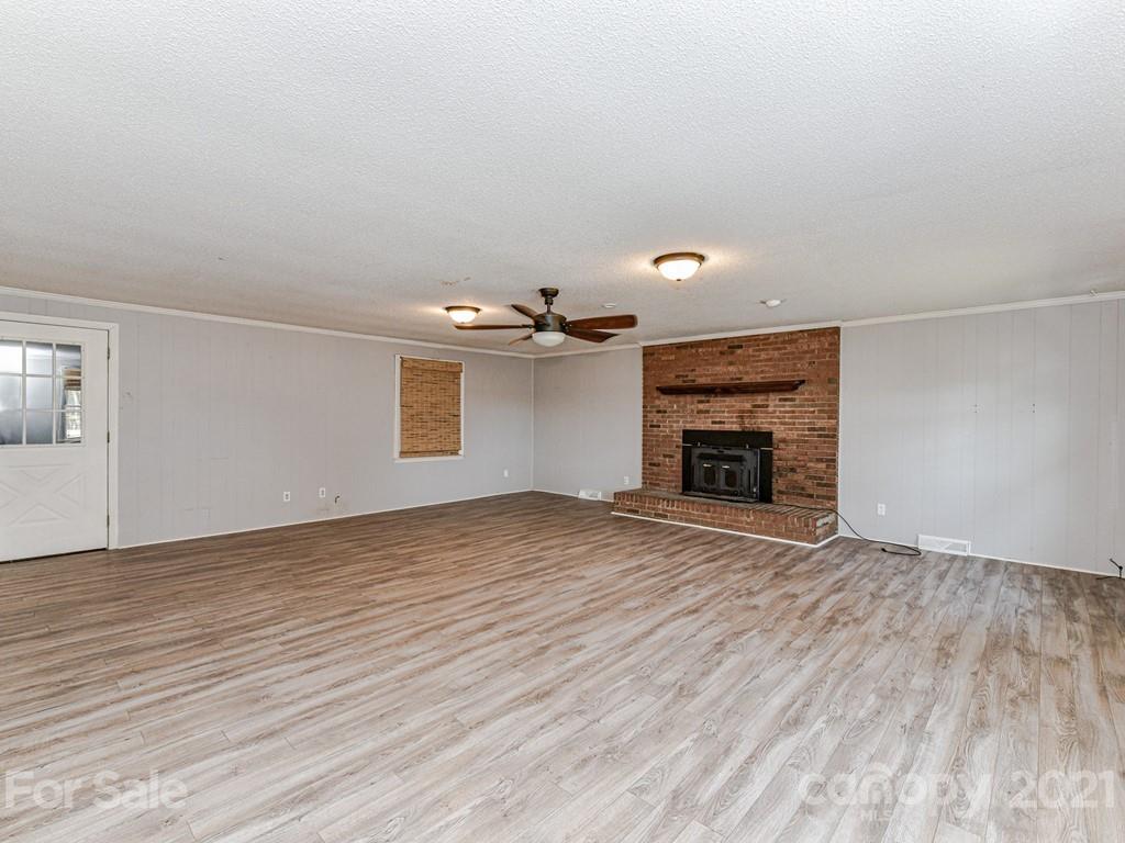 515 Sikes Mill Road Monroe, NC 28110 - Photo 16 of 33 a view of empty room with wooden floor and fireplace