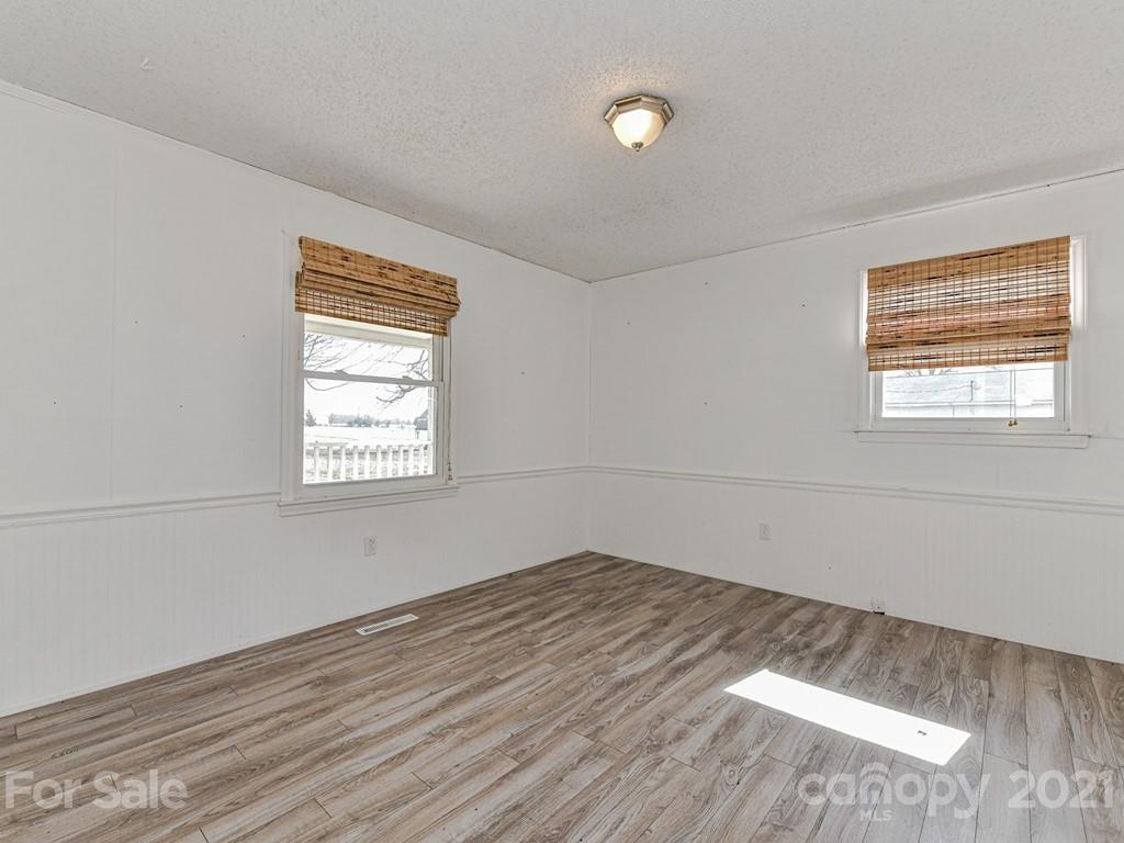 515 Sikes Mill Road Monroe, NC 28110 - Photo 23 of 33 an empty room with wooden floor and windows