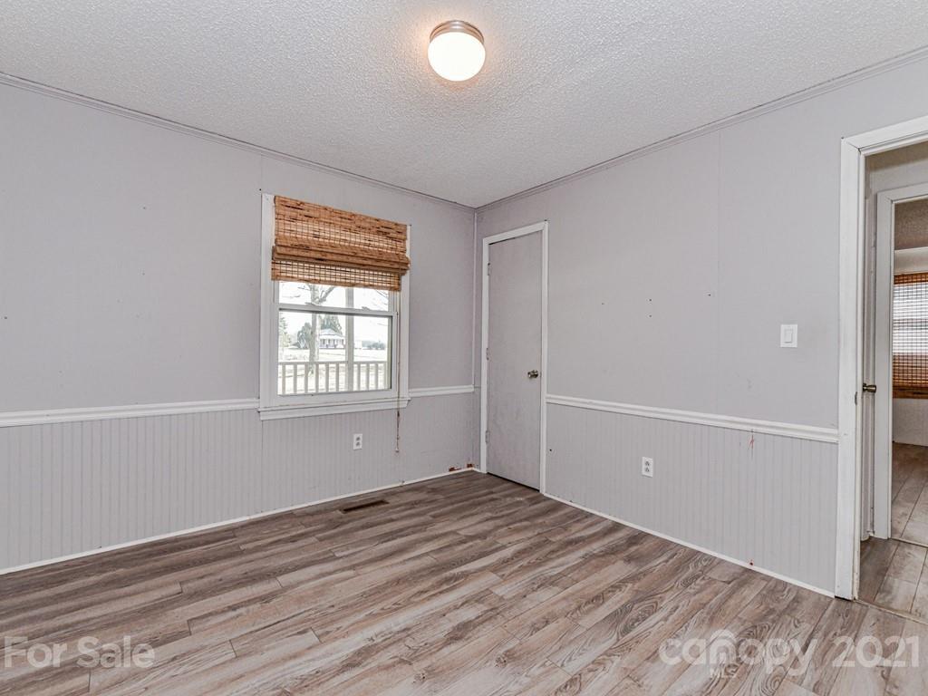 515 Sikes Mill Road Monroe, NC 28110 - Photo 27 of 33 an empty room with wooden floor and windows