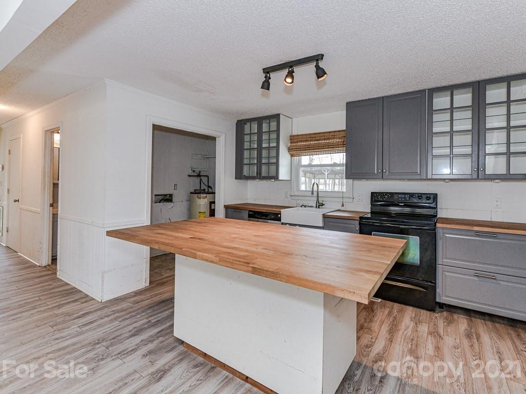 515 Sikes Mill Road Monroe, NC 28110 - Photo 10 of 33 a large kitchen with stainless steel appliances a stove a sink dishwasher and cabinets with wooden floor