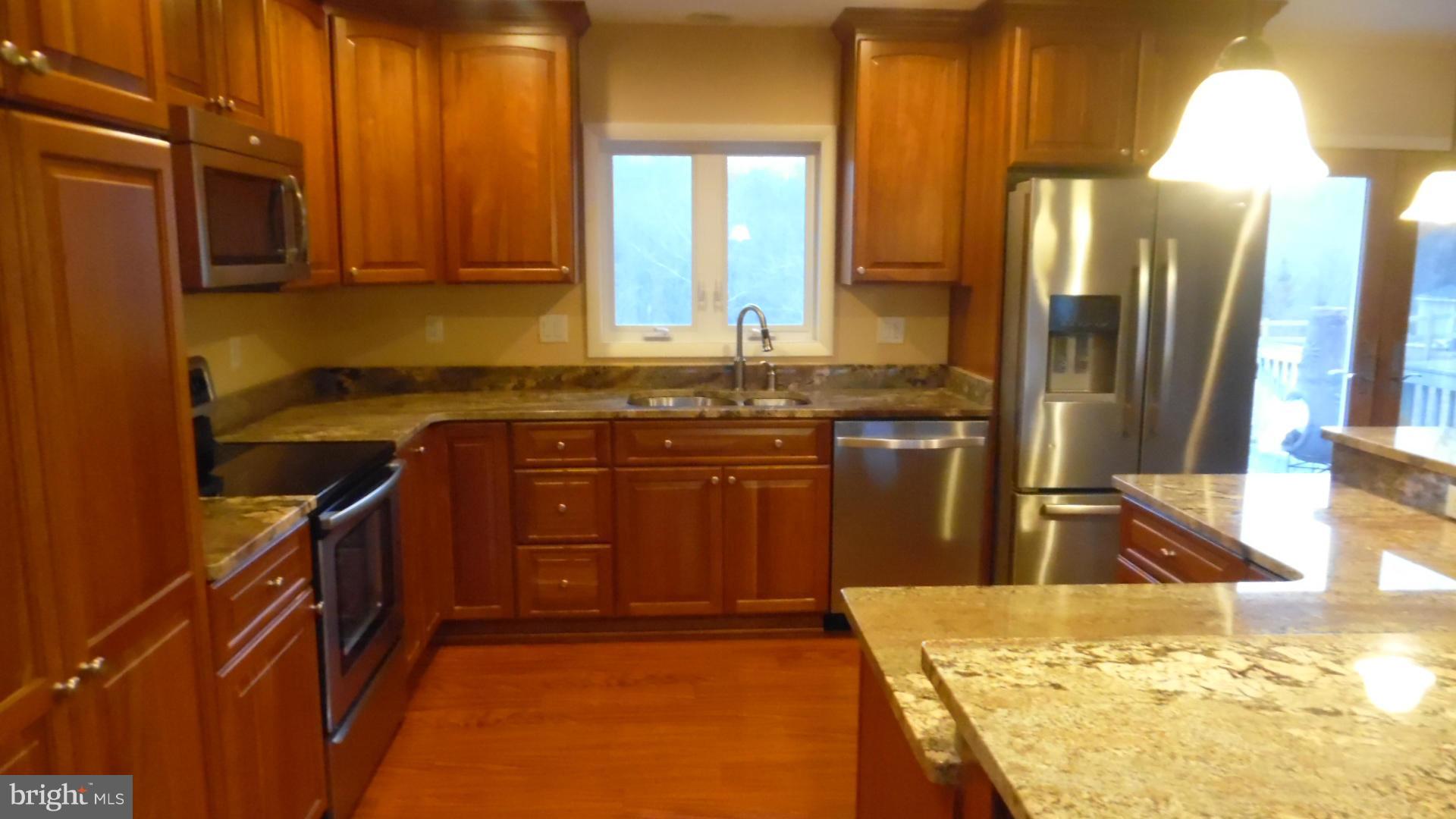 17913 Marshall Mill Road Hampstead, MD 21074 - Photo 11 of 16 a kitchen with stainless steel appliances granite countertop a sink stove and refrigerator