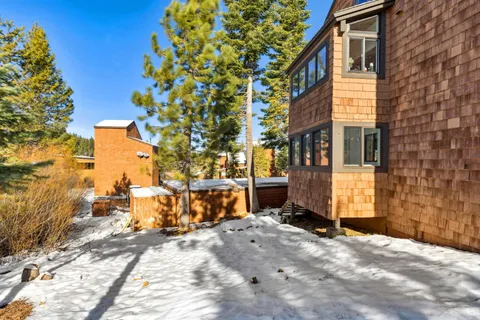 a view of a brick house with a large tree