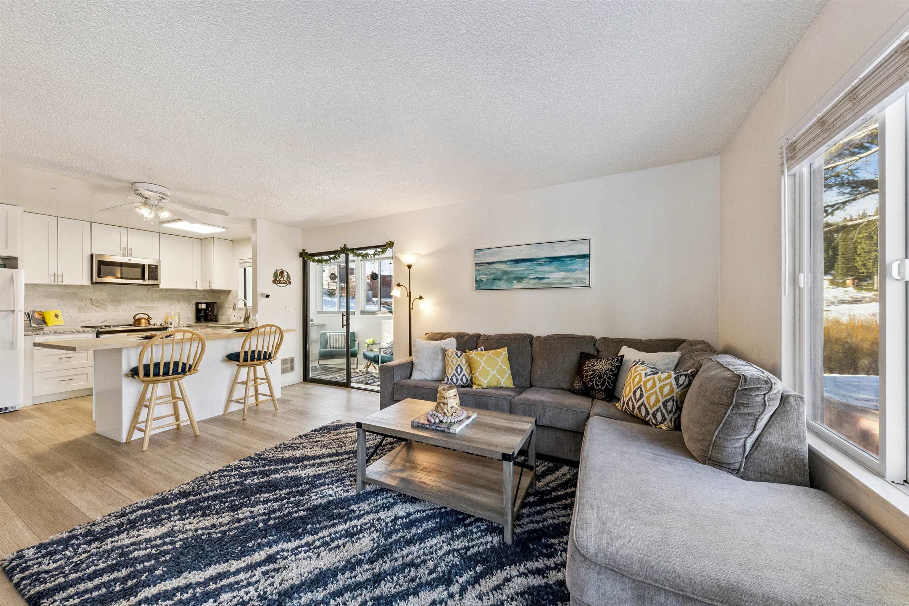 11727 Snowpeak Way, Unit 574 Truckee, CA 96161 - Photo 2 of 15 a living room with furniture wooden floor and a view of kitchen