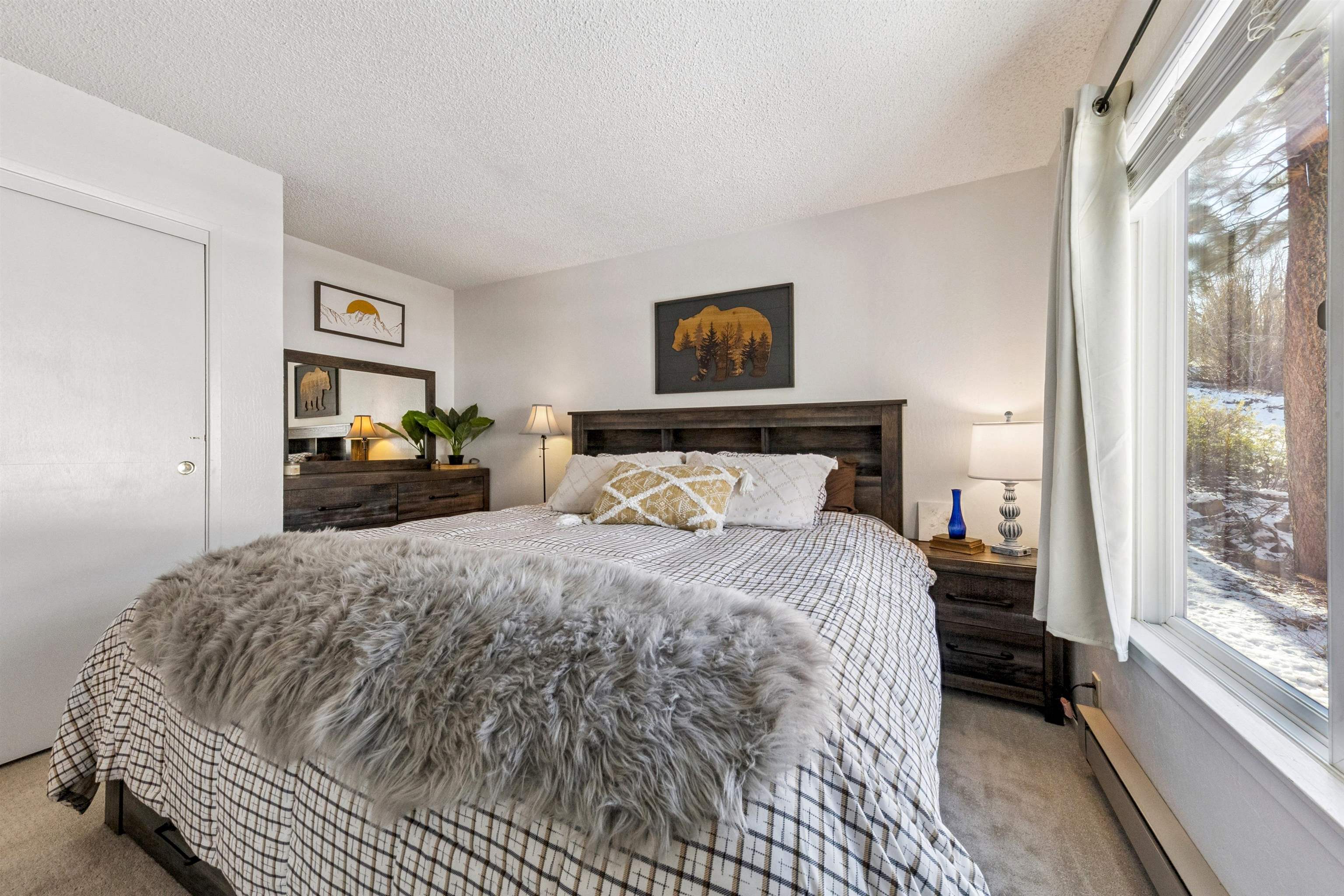 11727 Snowpeak Way, Unit 574 Truckee, CA 96161 - Photo 6 of 15 a bedroom with a bed and a large mirror next to a window