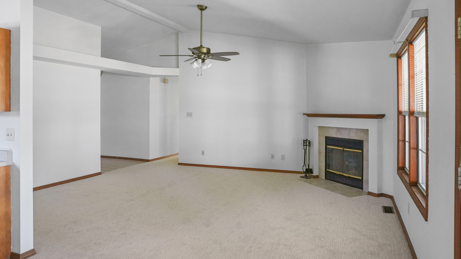 821 Park Drive Rantoul, IL 61866 - Photo 6 of 31 an empty room with a fireplace and a ceiling fan