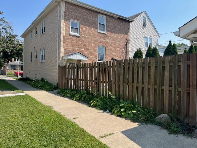 6100 South Kenneth Avenue, Unit 2 Chicago, IL 60629 - Photo 13 of 14 a view of a house with a small yard and wooden fence