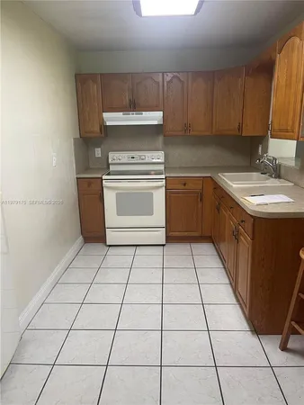 a kitchen with a stove top oven cabinets a sink and a counter top space
