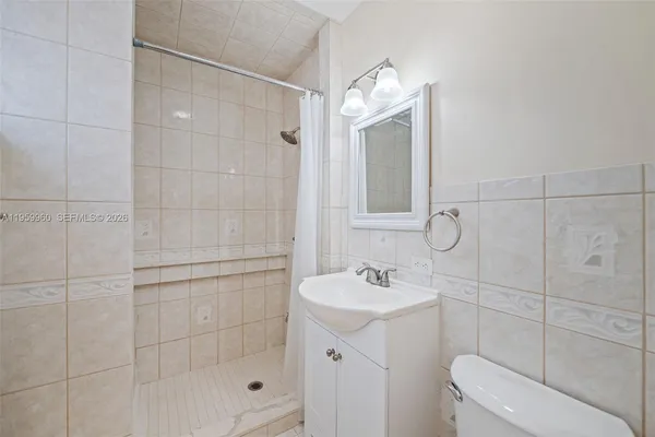 a bathroom with a shower a mirror and a sink
