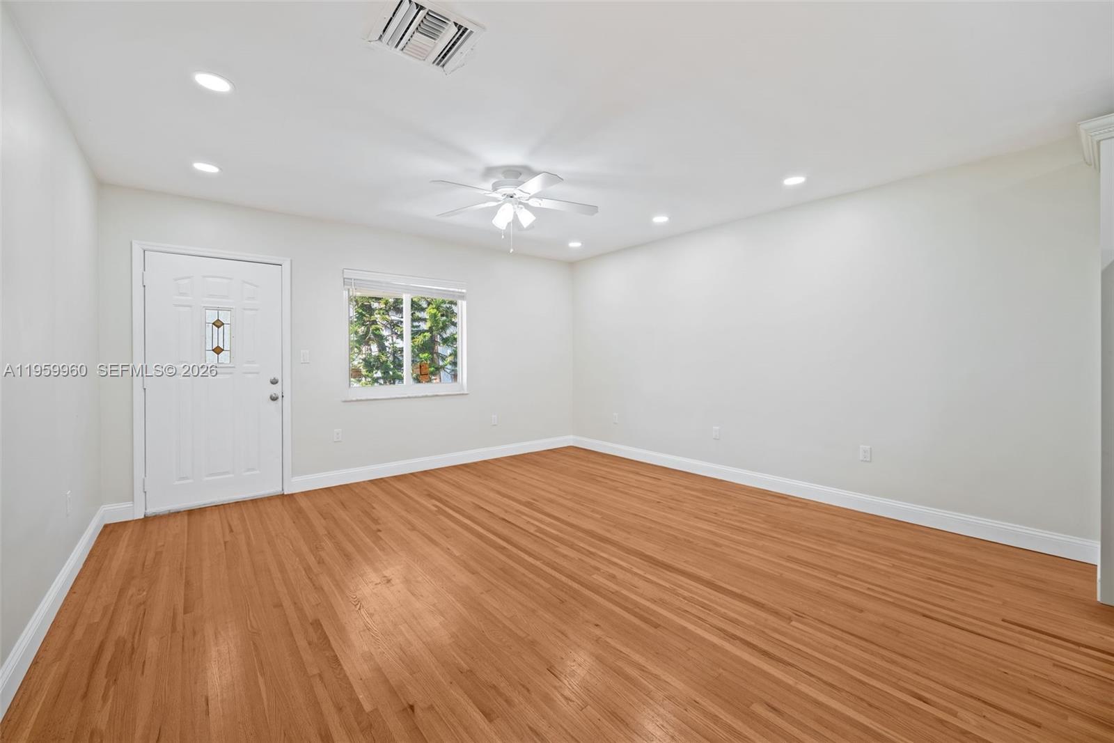1082 92nd Street, Unit 2 Bay Harbor Islands, FL 33154 - Photo 3 of 19 wooden floor in an empty room with a window