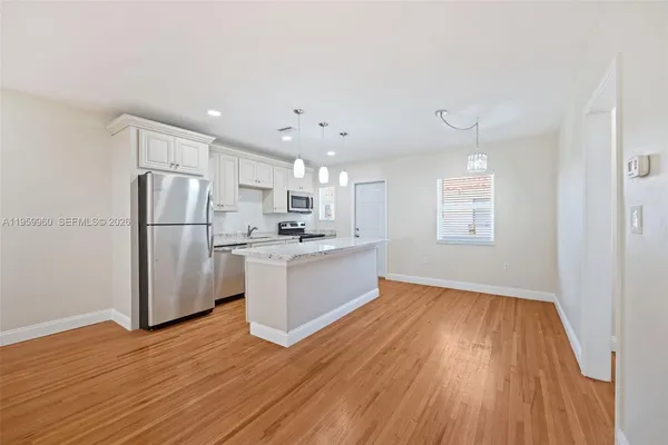 a kitchen with a refrigerator and white cabinets