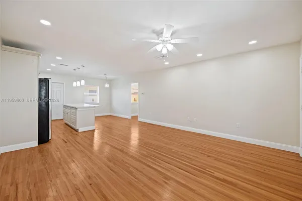 a view of an empty room with wooden floor