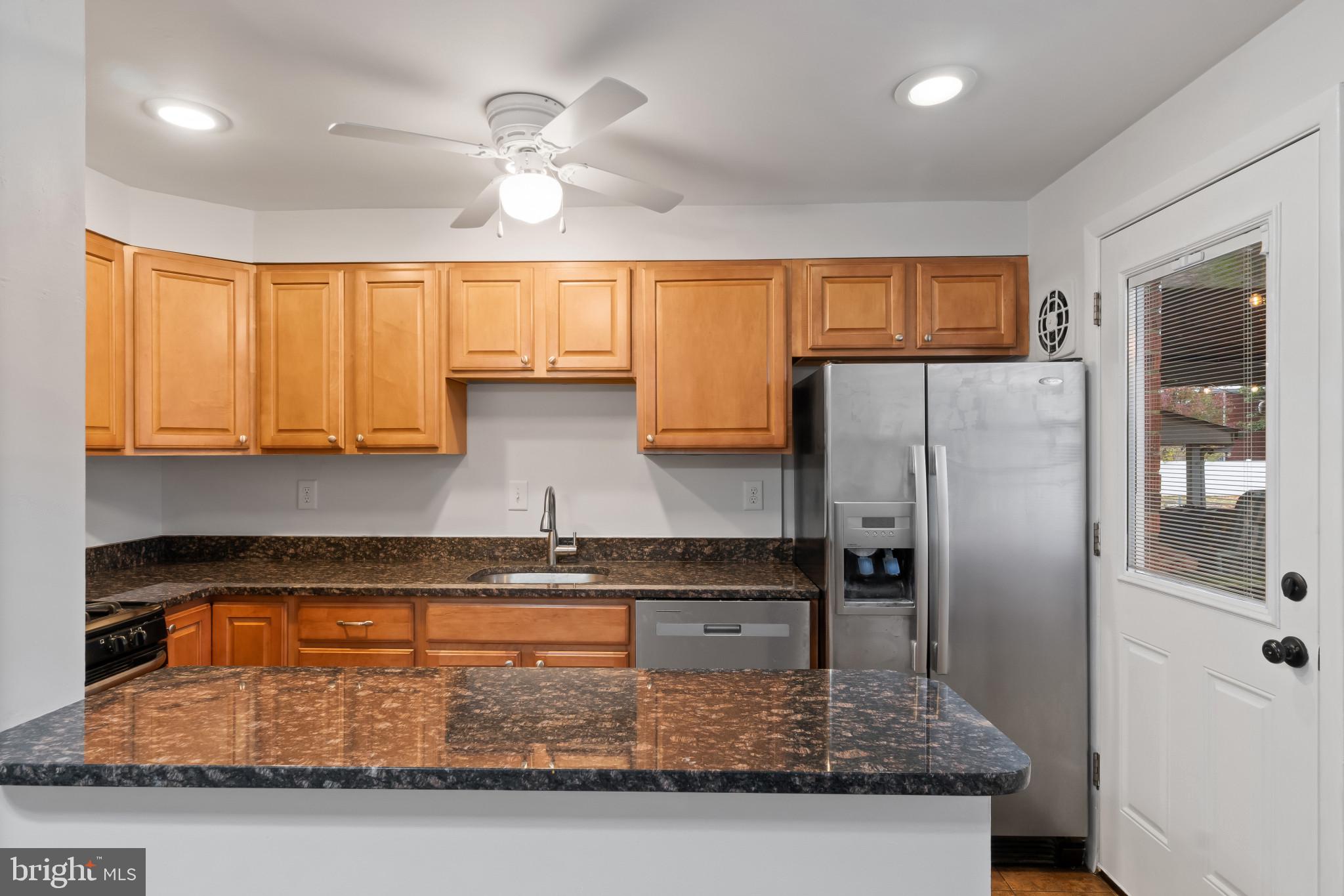 8146 Del Haven Road Baltimore, MD 21222 - Photo 11 of 35 a kitchen with kitchen island granite countertop a refrigerator a sink and dishwasher