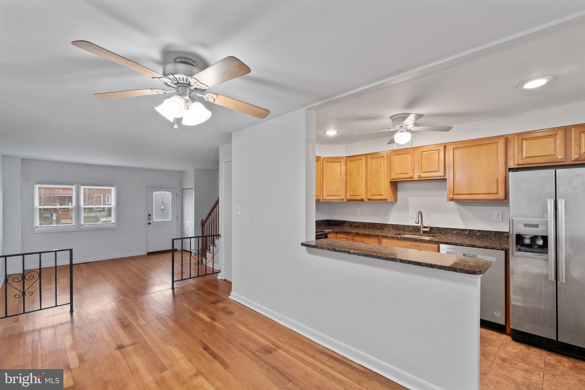 8146 Del Haven Road Baltimore, MD 21222 - Photo 8 of 35 a kitchen with stainless steel appliances granite countertop a refrigerator a sink dishwasher a stove and white countertops with wooden floor