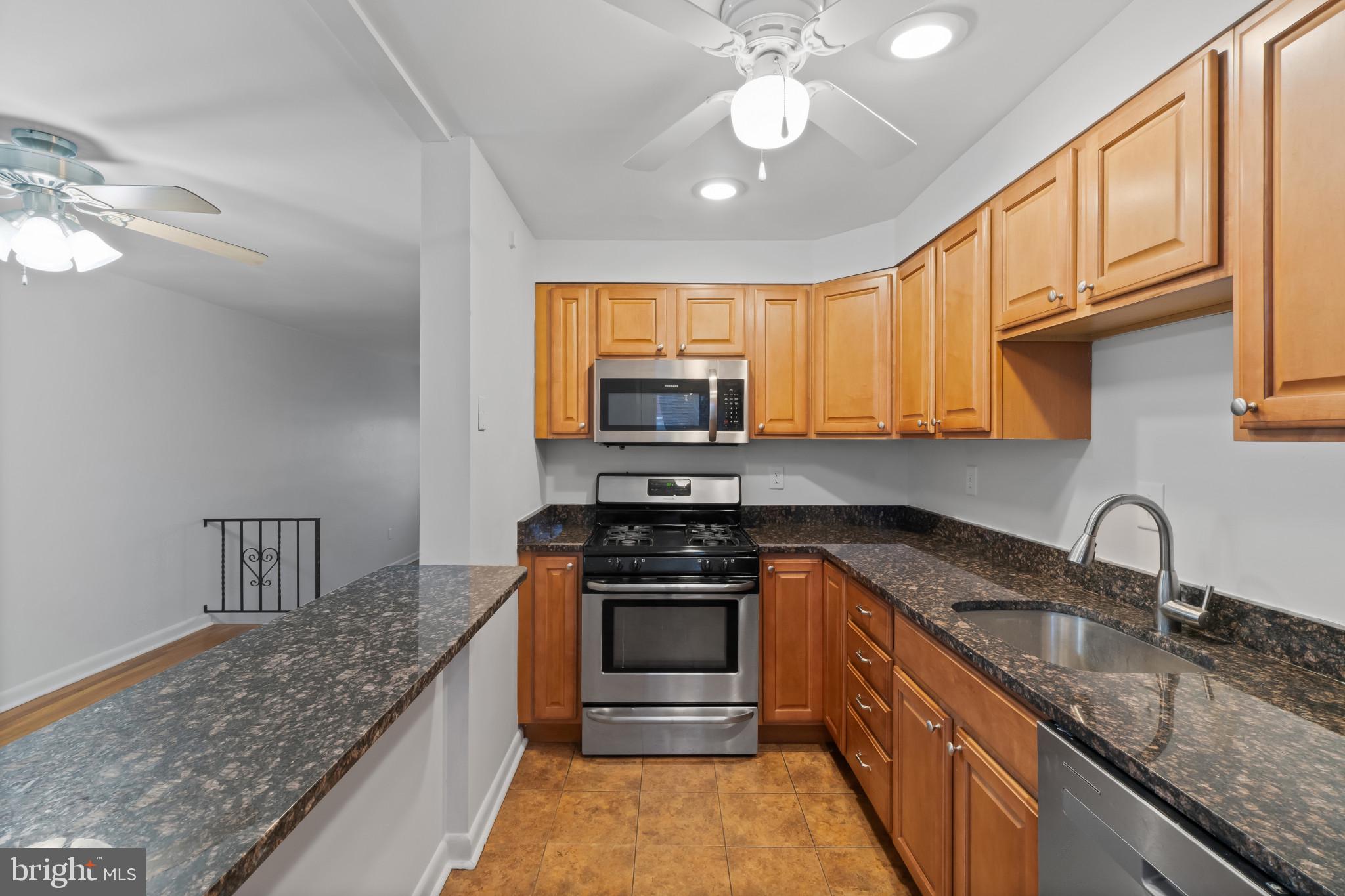 8146 Del Haven Road Baltimore, MD 21222 - Photo 10 of 35 a kitchen with granite countertop a stove sink and microwave