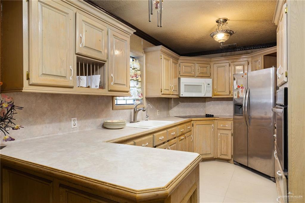 117 Hernandez Road Rio Grande City, TX 78582 - Photo 8 of 23 a kitchen with stainless steel appliances sinks a refrigerator and cabinets