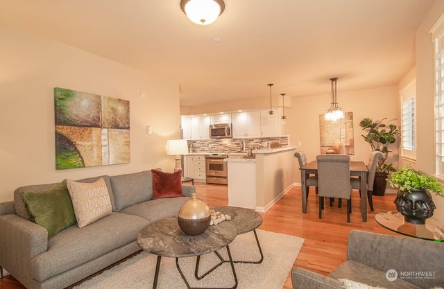 a living room with furniture and a dining table with kitchen view
