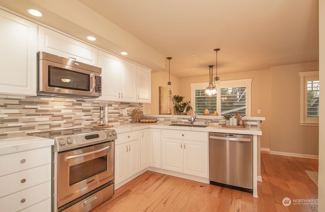a kitchen with stainless steel appliances granite countertop a stove and a sink