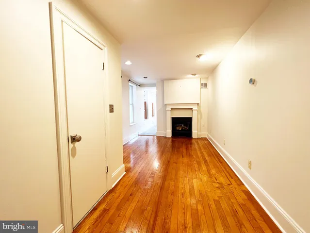 a view of livingroom with kitchen and wooden floor