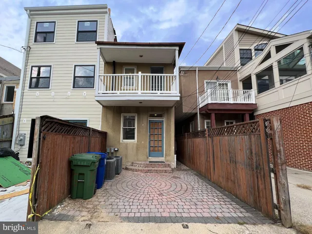 a view of a house with entryway and a wooden fence