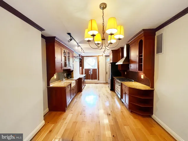 a large kitchen with stainless steel appliances granite countertop a stove a refrigerator a oven with a dining table and chairs