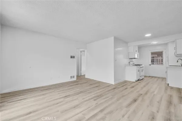a view of empty room with wooden floor and window
