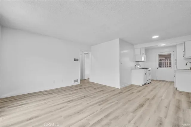 a view of empty room with wooden floor and window