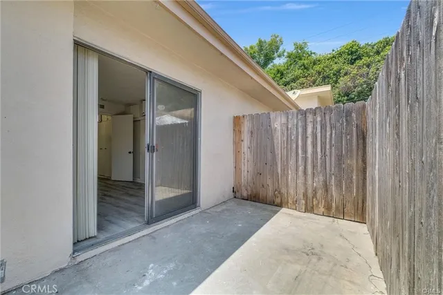 a view of a patio with table and chairs potted plants and palm tree