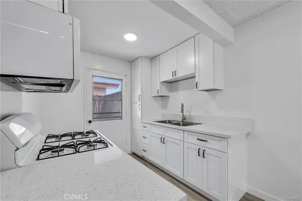 a kitchen with stainless steel appliances a sink stove and cabinets