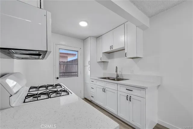 a kitchen with stainless steel appliances a sink stove and cabinets