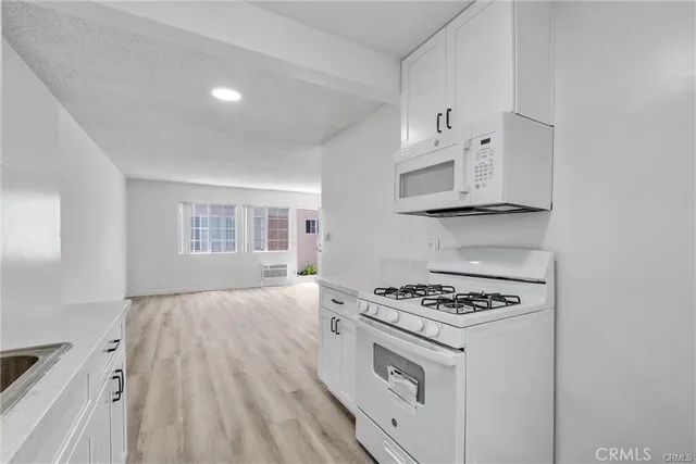 a kitchen with white cabinets and appliances
