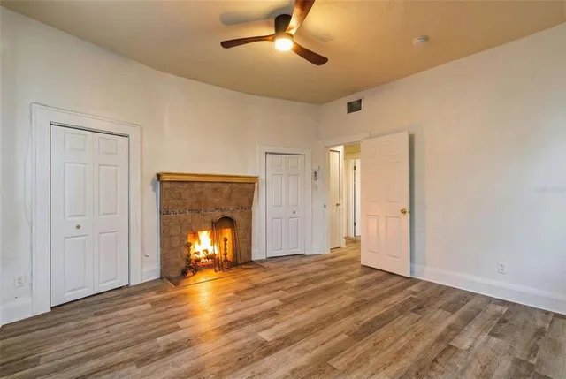 a view of empty room with wooden floor fireplace and windows