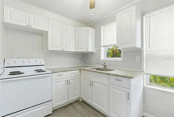 a kitchen with cabinets appliances a sink and a window