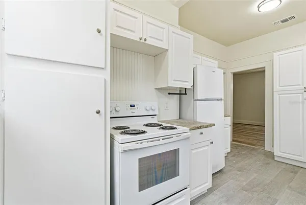 a kitchen with stainless steel appliances white cabinets and white appliances