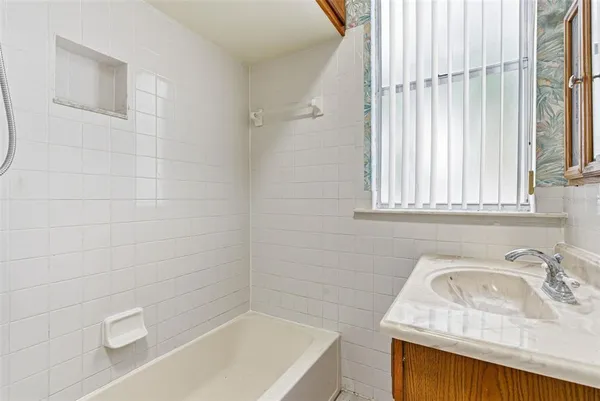 a bathroom with a sink a bathtub and window