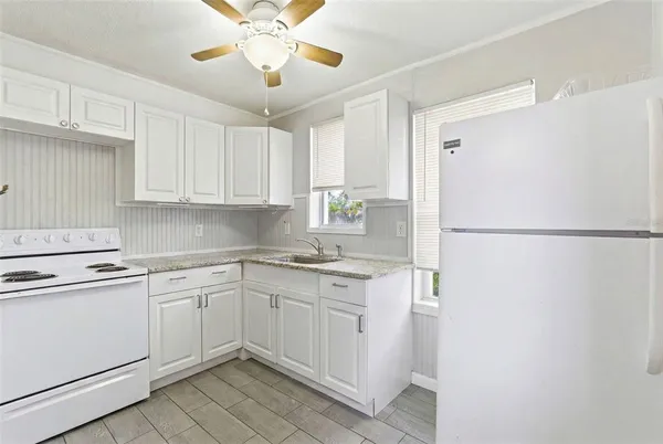 a kitchen with a sink a refrigerator and cabinets
