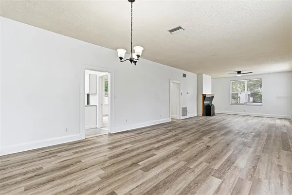 a view of empty room with wooden floor and ceiling fan
