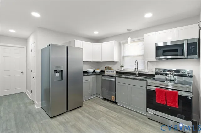 a kitchen with stainless steel appliances granite countertop a refrigerator a stove a sink and a microwave