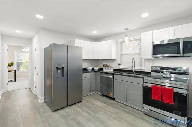 a kitchen with stainless steel appliances granite countertop a refrigerator stove and sink