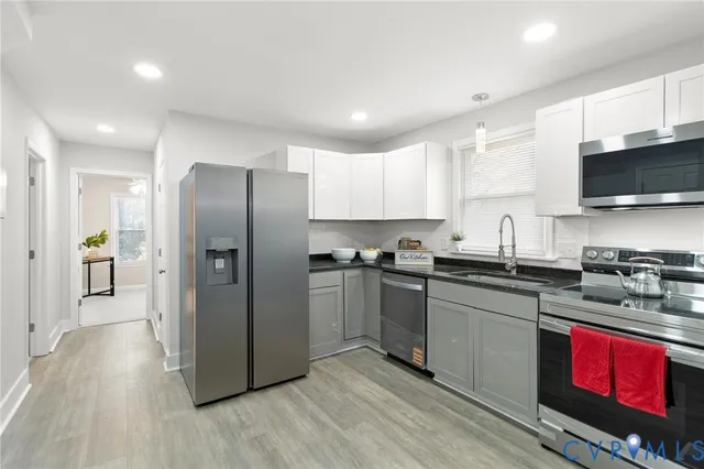 a kitchen with stainless steel appliances granite countertop a refrigerator stove and sink