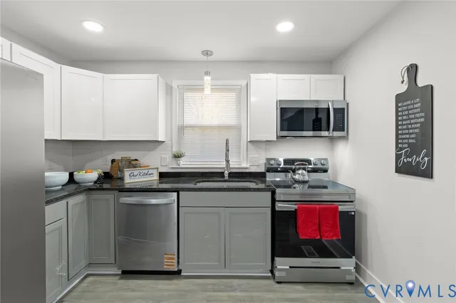 a kitchen with stainless steel appliances granite countertop a stove a sink and a microwave