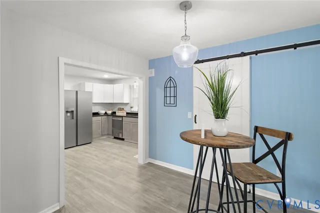 a kitchen with stainless steel appliances a table and chairs in it
