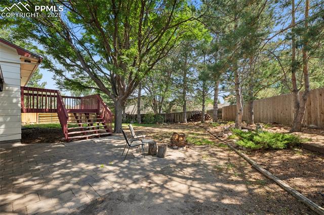 7233 River Bend Road Colorado Springs, CO 80911 - Photo 36 of 44 Paver area for entertainment area or fire pit use. Large established trees